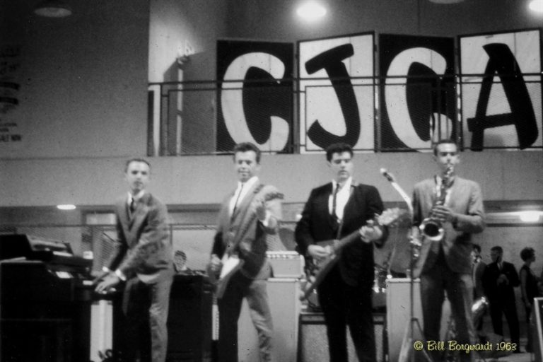 Black and White, 1960's rock band. Left to right; piano, guitar, guirat and sax. Above is the letters CJCA