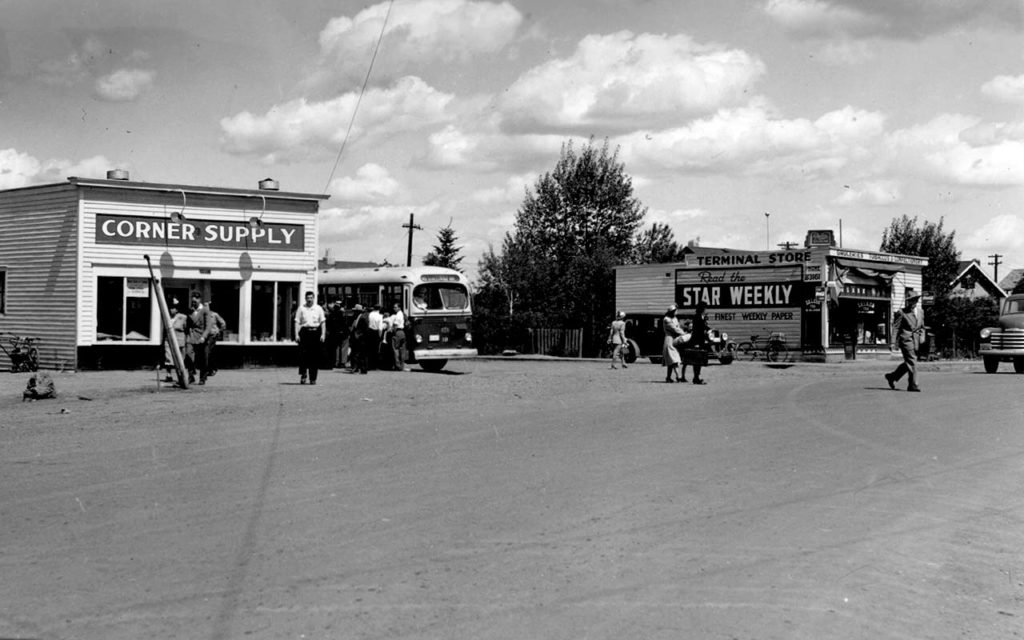B&W photo of the corner of 149th St and Stony Plain Road, 1948. A City of Edmonton bus is parked beside Corner Supply.